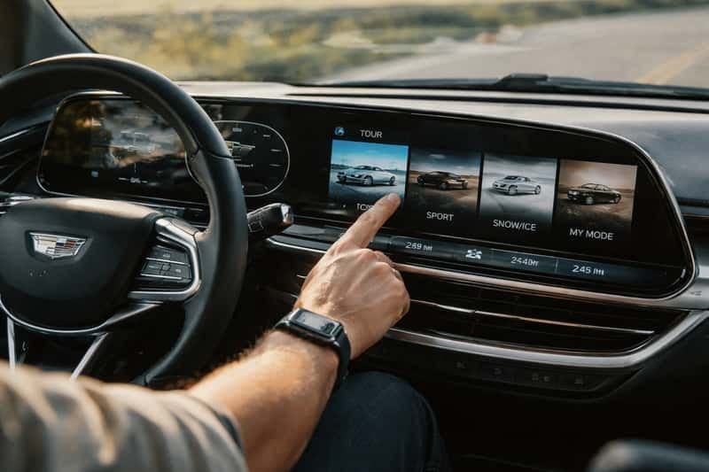 Cadillac Lyriq dashboard display showing driving mode Cadillac Lyriq dashboard display showing driving mode selector with range estimates for each mode highlighted on screen